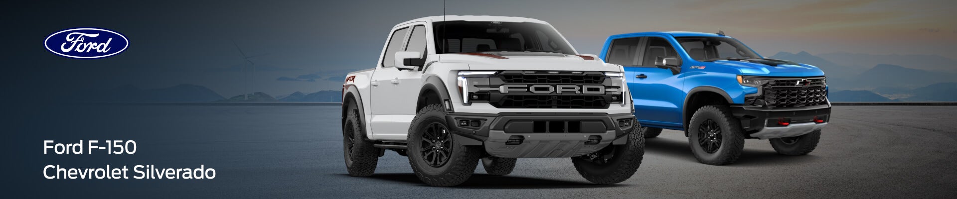A white Ford F-150 Raptor and a blue Chevy Silverado parked in front of a mountain backdrop.